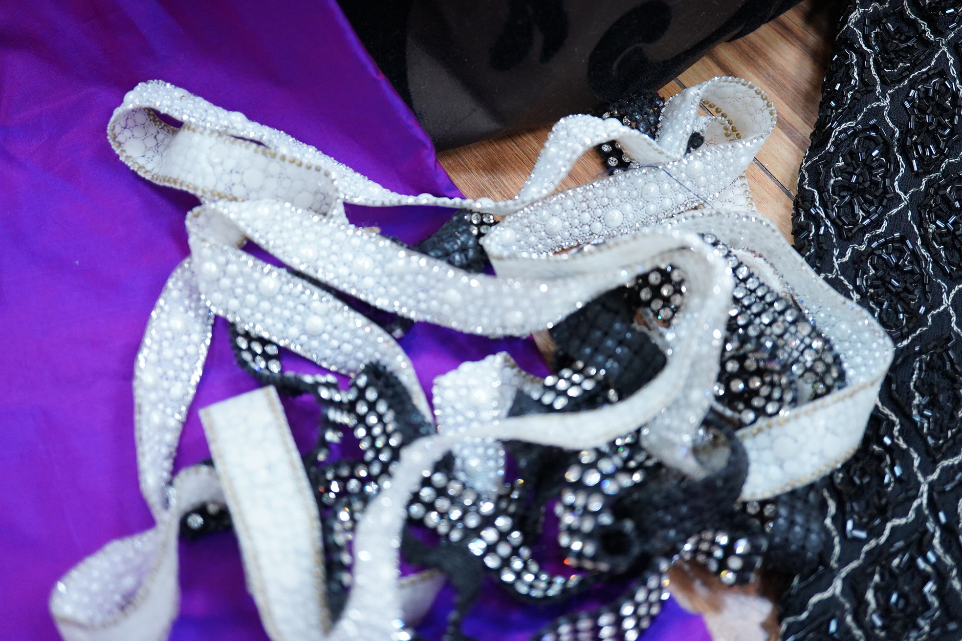 A length of silk velvet flocked taffeta, a purple silk panel, a mid century beaded length and two lengths of late 20th century braiding